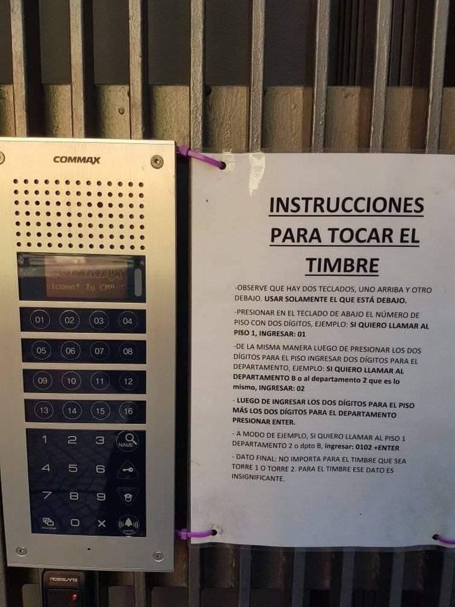 Cartel con instrucciones para tocar el timbre, pegado junto a un panel de portero eléctrico Commax